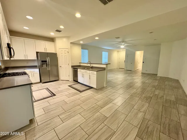 a kitchen with stainless steel appliances granite countertop a stove a sink dishwasher and a refrigerator