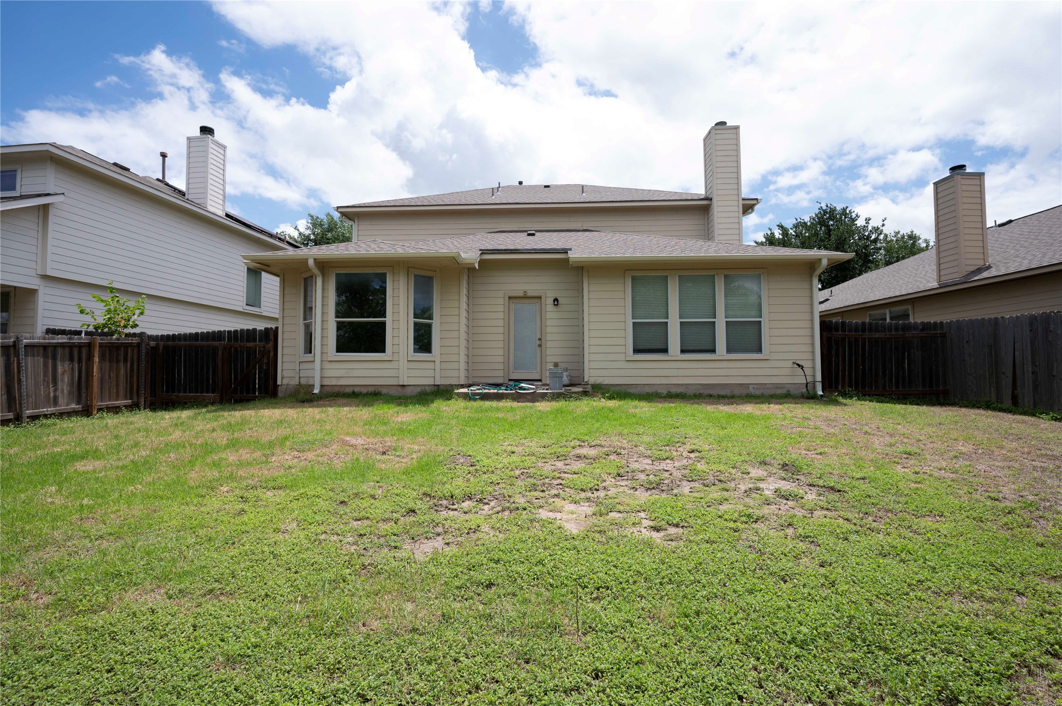 2070 Intrepid Drive Buda, TX 78610 - Photo 27 of 31 A spacious backyard with mature landscaping offers potential for outdoor enjoyment.