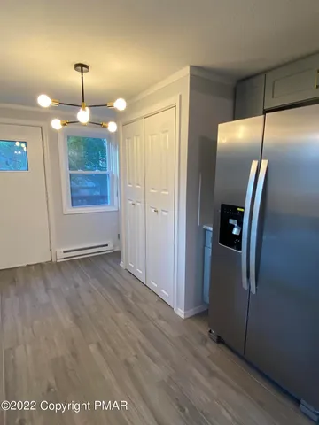 an empty room with wooden floor and mirror