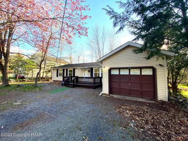 a view of house with a yard and large tree
