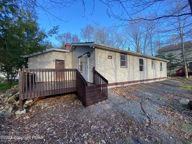 a view of a house with a yard and wooden fence