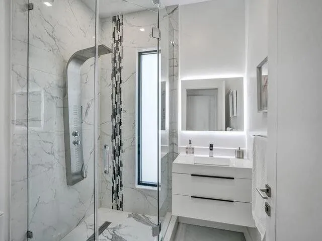 a bathroom with a shower sink and mirror