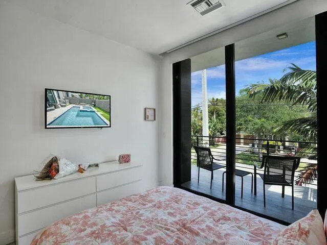 a bedroom with a bed and a large window