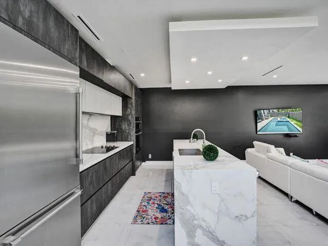 a kitchen with stainless steel appliances kitchen island granite countertop a refrigerator and a stove