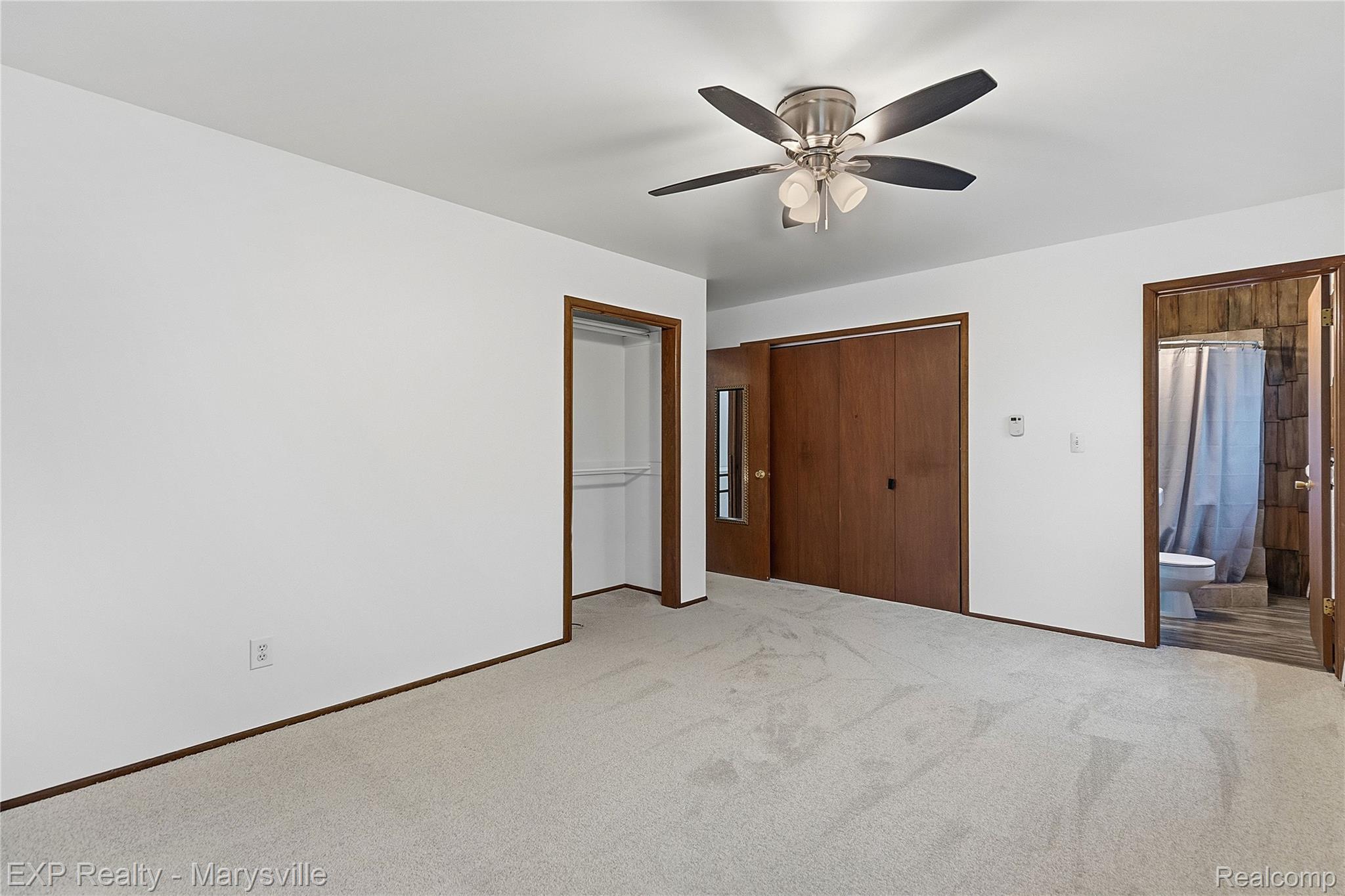 3345 Beach Road Port Huron, MI 48060 - Photo 18 of 89 Unfurnished bedroom featuring light colored carpet, connected bathroom, and a ceiling fan