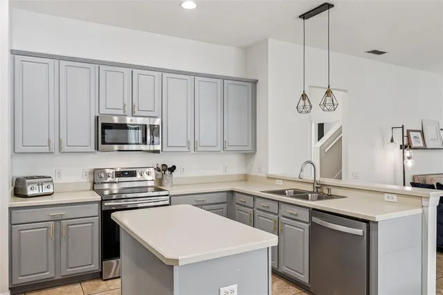 a kitchen with stainless steel appliances granite countertop a sink a stove a microwave and cabinets