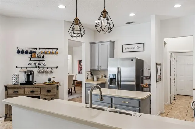 a kitchen with stainless steel appliances granite countertop a refrigerator and a stove top oven