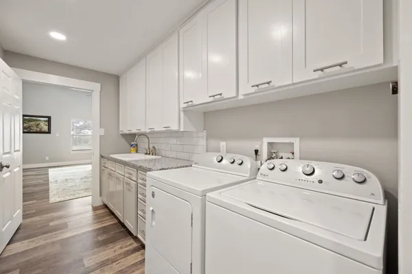 a view of washer and dryer with white cabinets