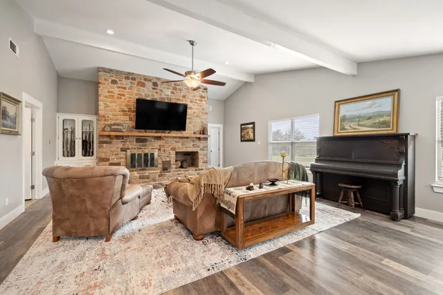 a living room with furniture a flat screen tv and a fireplace