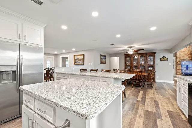 a large kitchen with kitchen island a large counter space a sink appliances and cabinets
