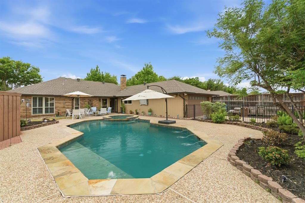 2307 Castle Rock Road Carrollton, TX 75007 - Photo 31 of 34 The property features a private pool with an integrated spa, surrounded by a textured aggregate patio