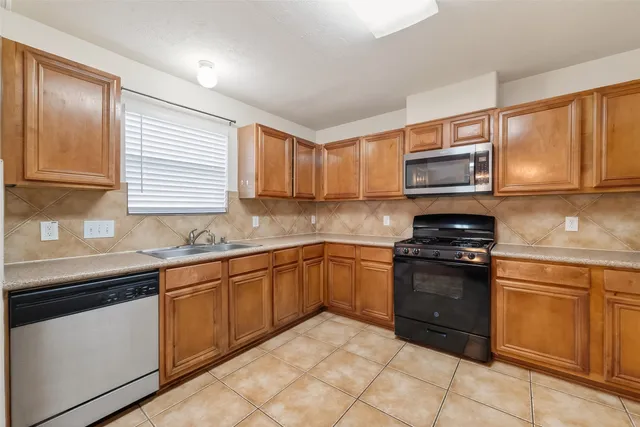 a kitchen with stainless steel appliances granite countertop a sink and stove top oven