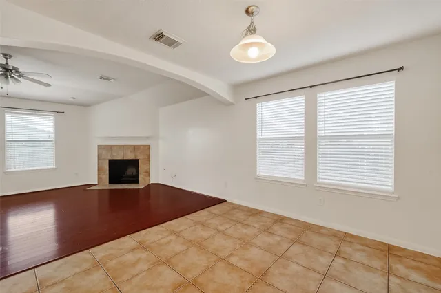 a view of an empty room with window and wooden floor