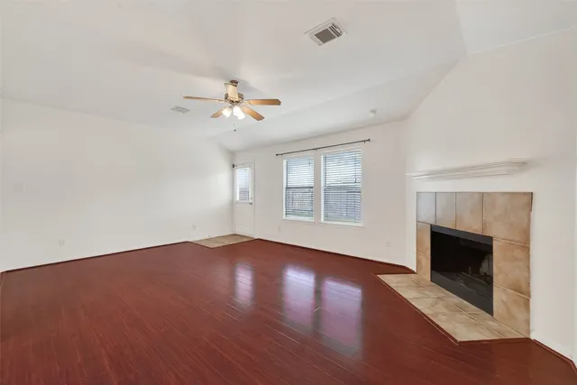 an empty room with windows fireplace and a sink