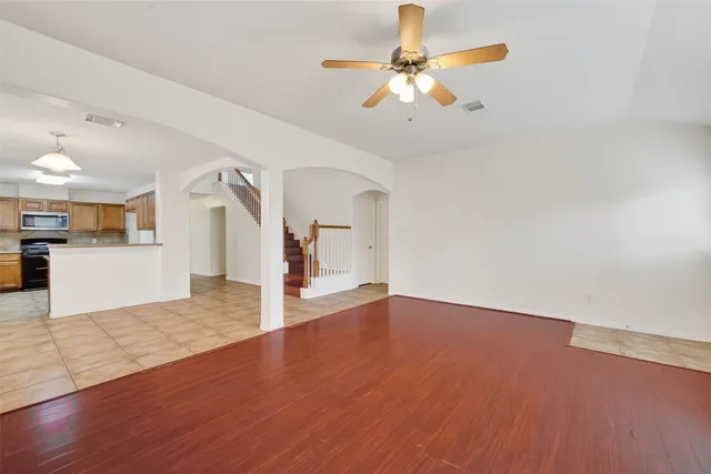 a view of a livingroom with wooden floor and a ceiling fan