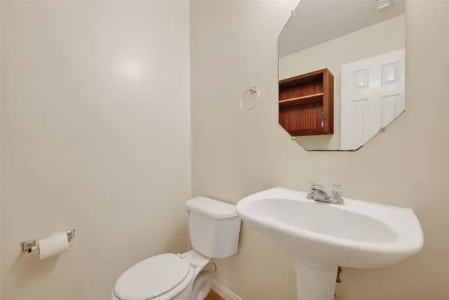 a bathroom with a toilet a sink and mirror