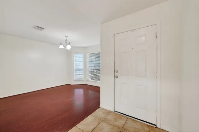 an empty room with chandelier fan