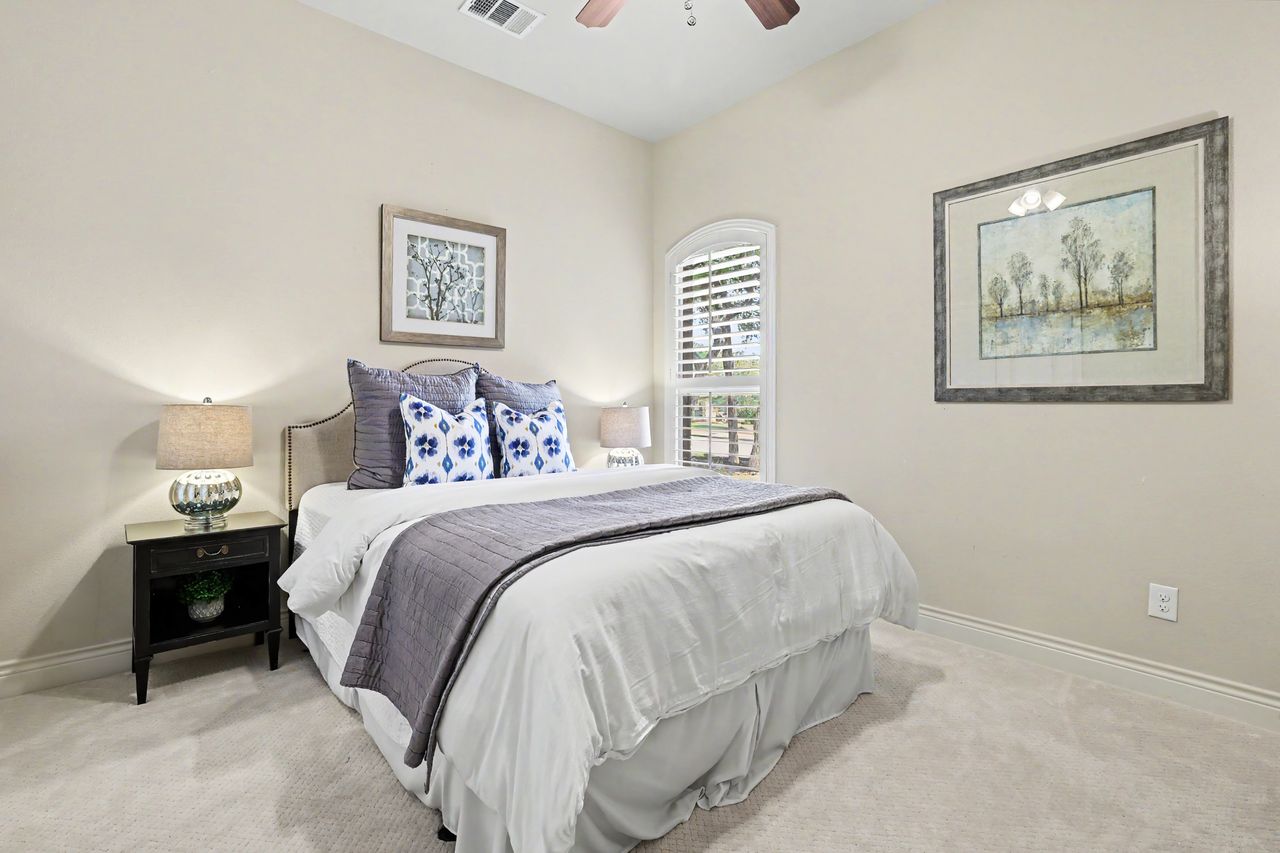 809 Prairie Dunes Drive Georgetown, TX 78628 - Photo 20 of 40 Restful bedroom featuring soft carpet and a serene arched window.