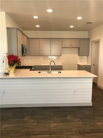 a view of kitchen with stainless steel appliances granite countertop a sink a stove and a wooden floors