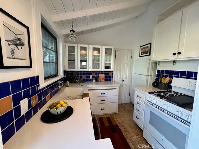 a kitchen with a stove a sink and a cabinets