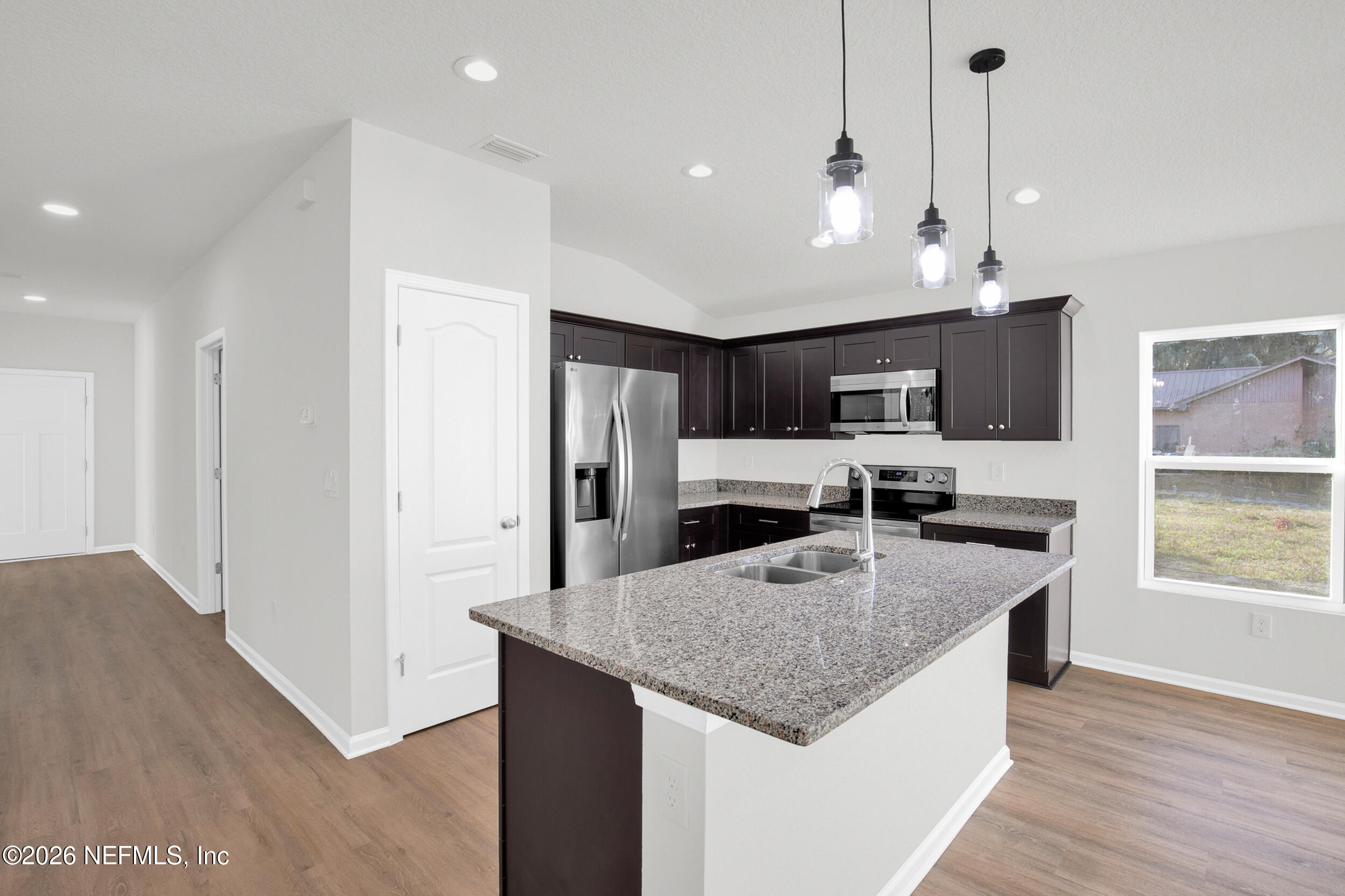 138 Kelly Smith School Road Palatka, FL 32177 - Photo 6 of 52 a kitchen with stainless steel appliances granite countertop a refrigerator a sink dishwasher a oven and a dining table with wooden floor