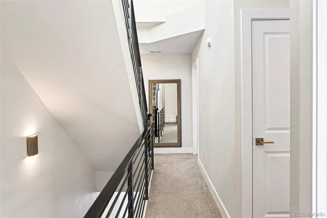 a view of a hallway with wooden floor and entryway