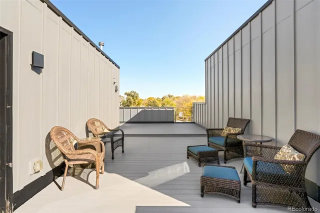a balcony with chairs and with potted plant