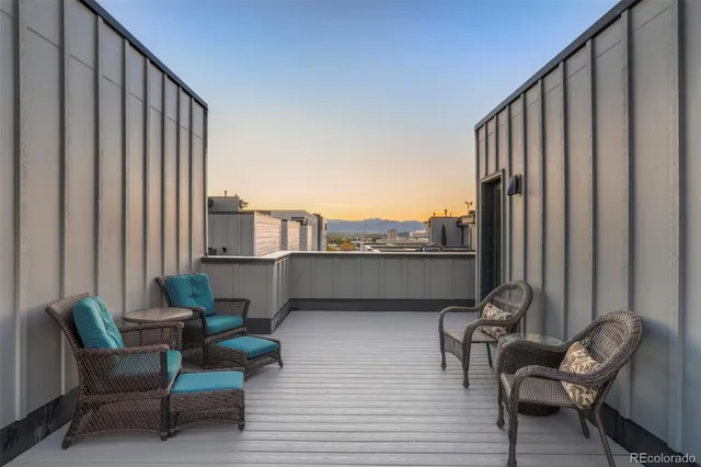 a view of a balcony with chairs and a potted plant