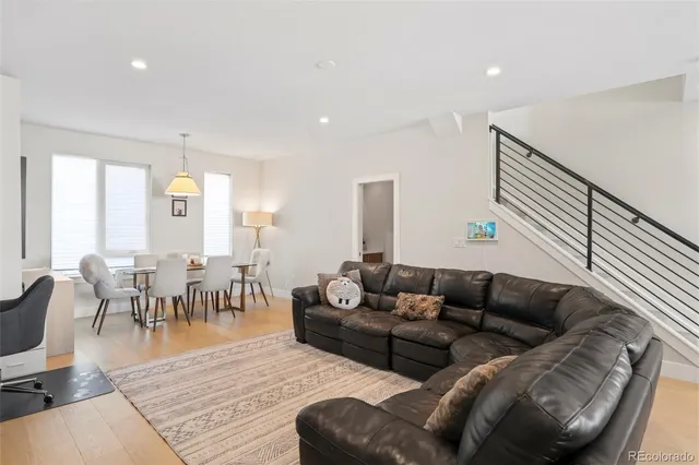 a living room with furniture and a dining table with wooden floor