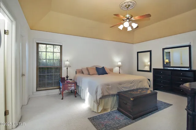 a spacious bedroom with a bed and a chandelier