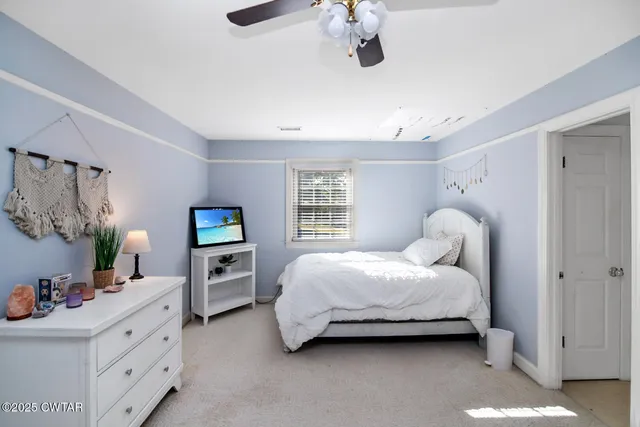 a spacious bedroom with a bed and a dresser