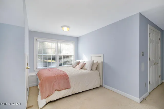 a bedroom with a bed and a large window