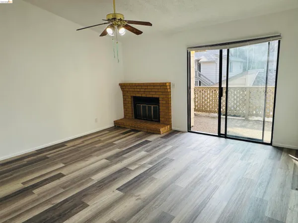 wooden floor fireplace and windows in an empty room