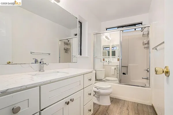 a bathroom with a granite countertop sink toilet a shower and a mirror