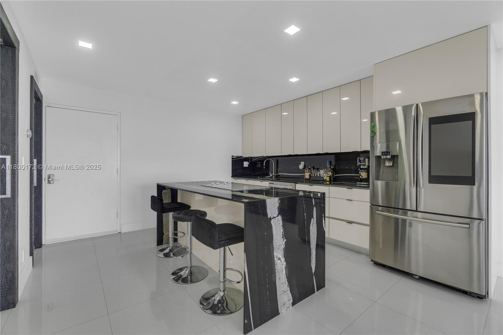 400 North Surf Road, Unit 504 Hollywood, FL 33019 - Photo 11 of 44 a kitchen with a refrigerator and chairs