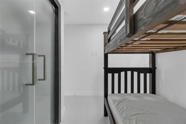a large white kitchen with kitchen island granite countertop a sink and white cabinets
