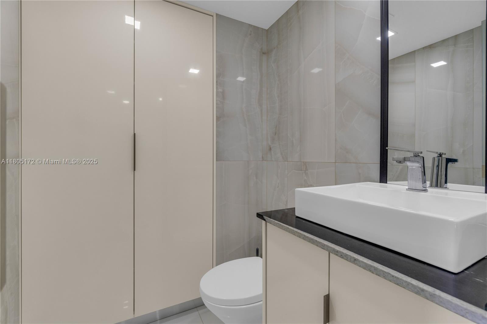 400 North Surf Road, Unit 504 Hollywood, FL 33019 - Photo 24 of 44 a bathroom with a sink a toilet a mirror and shower