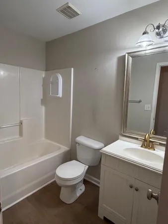 a bathroom with a toilet a sink a mirror and bathtub