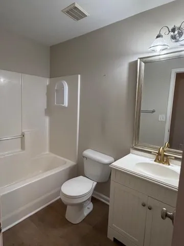a bathroom with a toilet a sink a mirror and bathtub