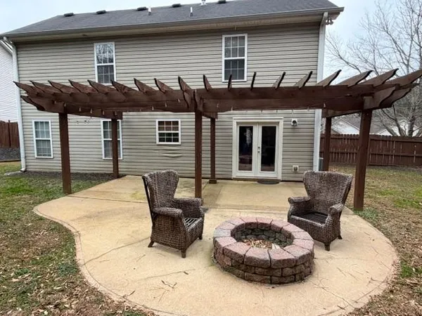 a view of a patio with a table and chairs and a barbeque
