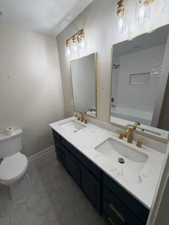 a bathroom with a double vanity sink toilet and a mirror