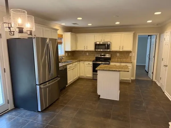 a kitchen with stainless steel appliances granite countertop a refrigerator a stove and a sink