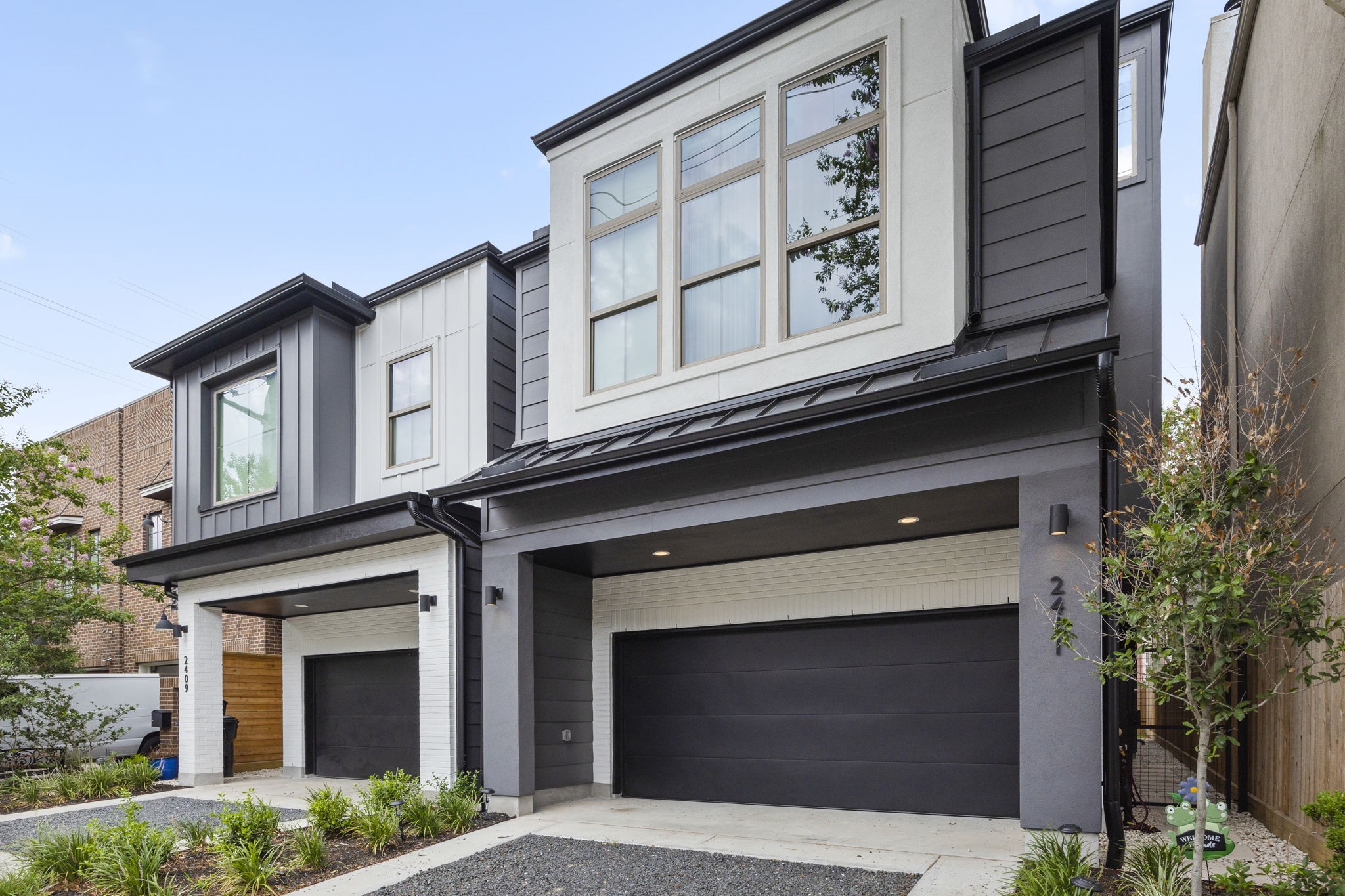 2411 Hazard Street Houston, TX 77019 - Photo 46 of 46 Additional view of the front elevation highlights the modern architectural style, featuring sleek lines and a combination of contrasting materials. The two-car garage and manicured landscaping add to the curb appeal, making this property a standout.