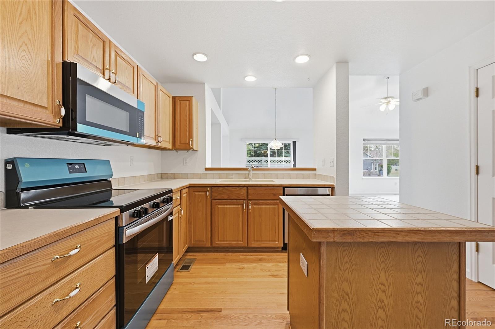 6383 Deframe Way Arvada, CO 80004 - Photo 15 of 49 a kitchen with stainless steel appliances granite countertop a stove a sink and a microwave