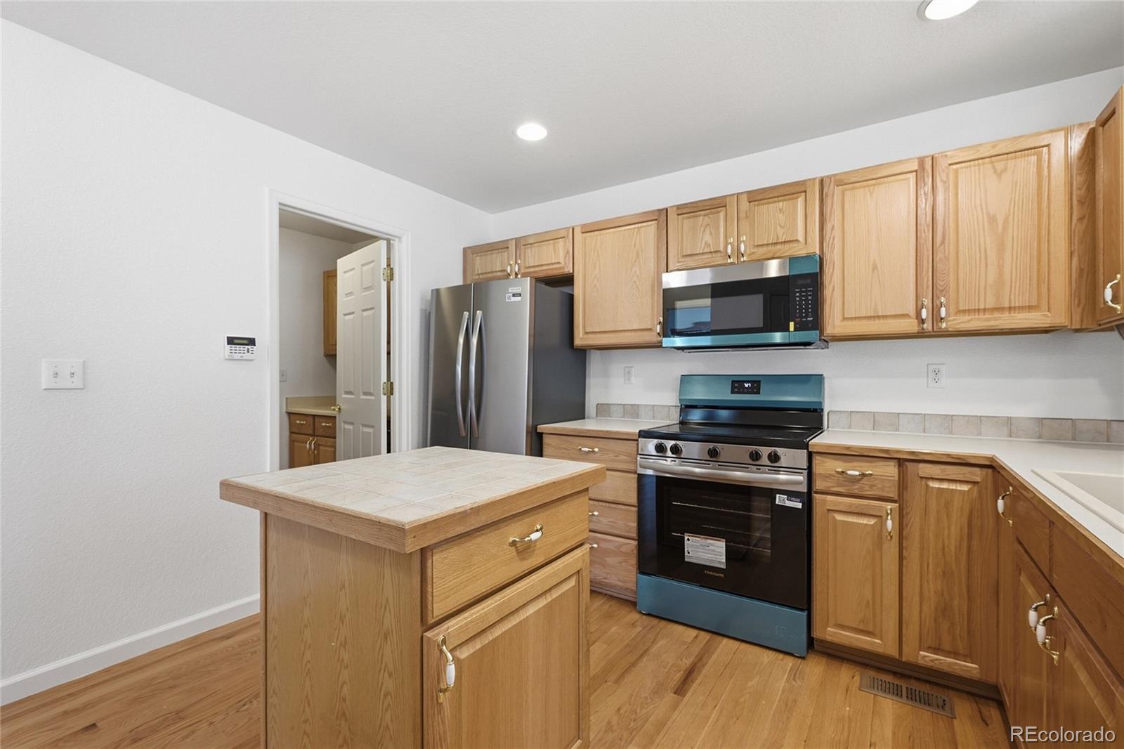 6383 Deframe Way Arvada, CO 80004 - Photo 16 of 49 a kitchen with a stove a sink and a refrigerator