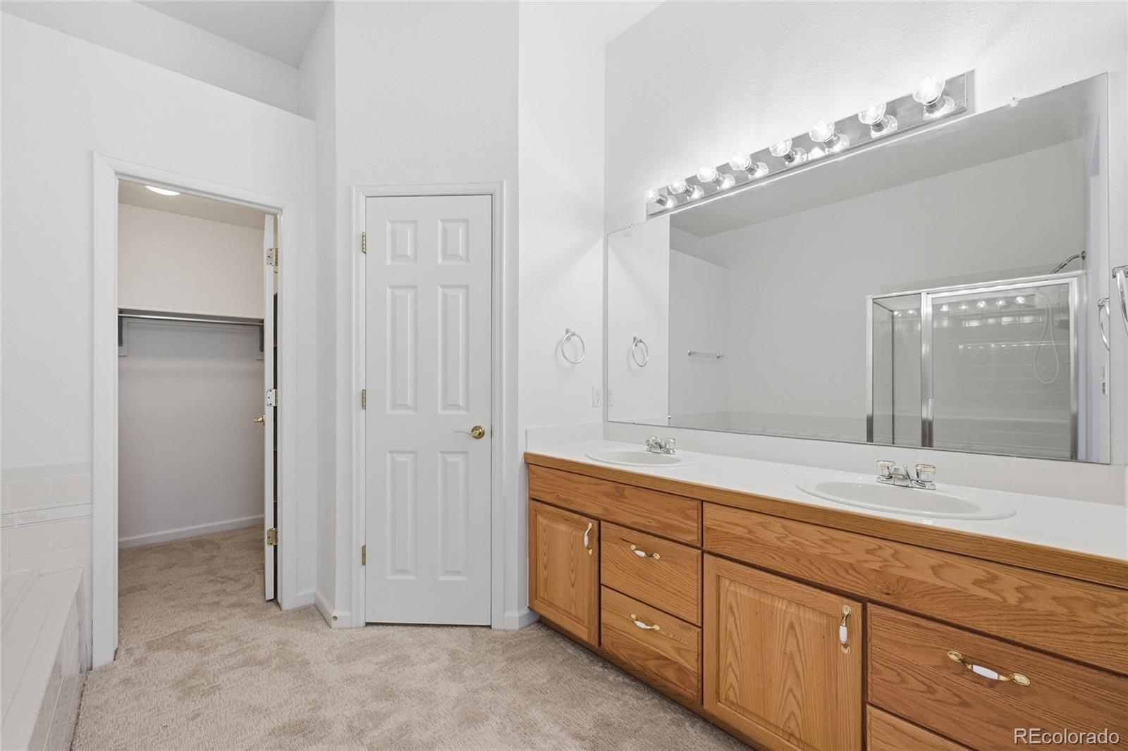 6383 Deframe Way Arvada, CO 80004 - Photo 22 of 49 a spacious bathroom with a double vanity sink mirror and