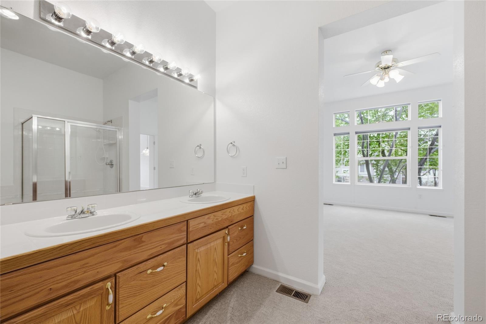 6383 Deframe Way Arvada, CO 80004 - Photo 24 of 49 a bathroom with a double vanity sink and a mirror