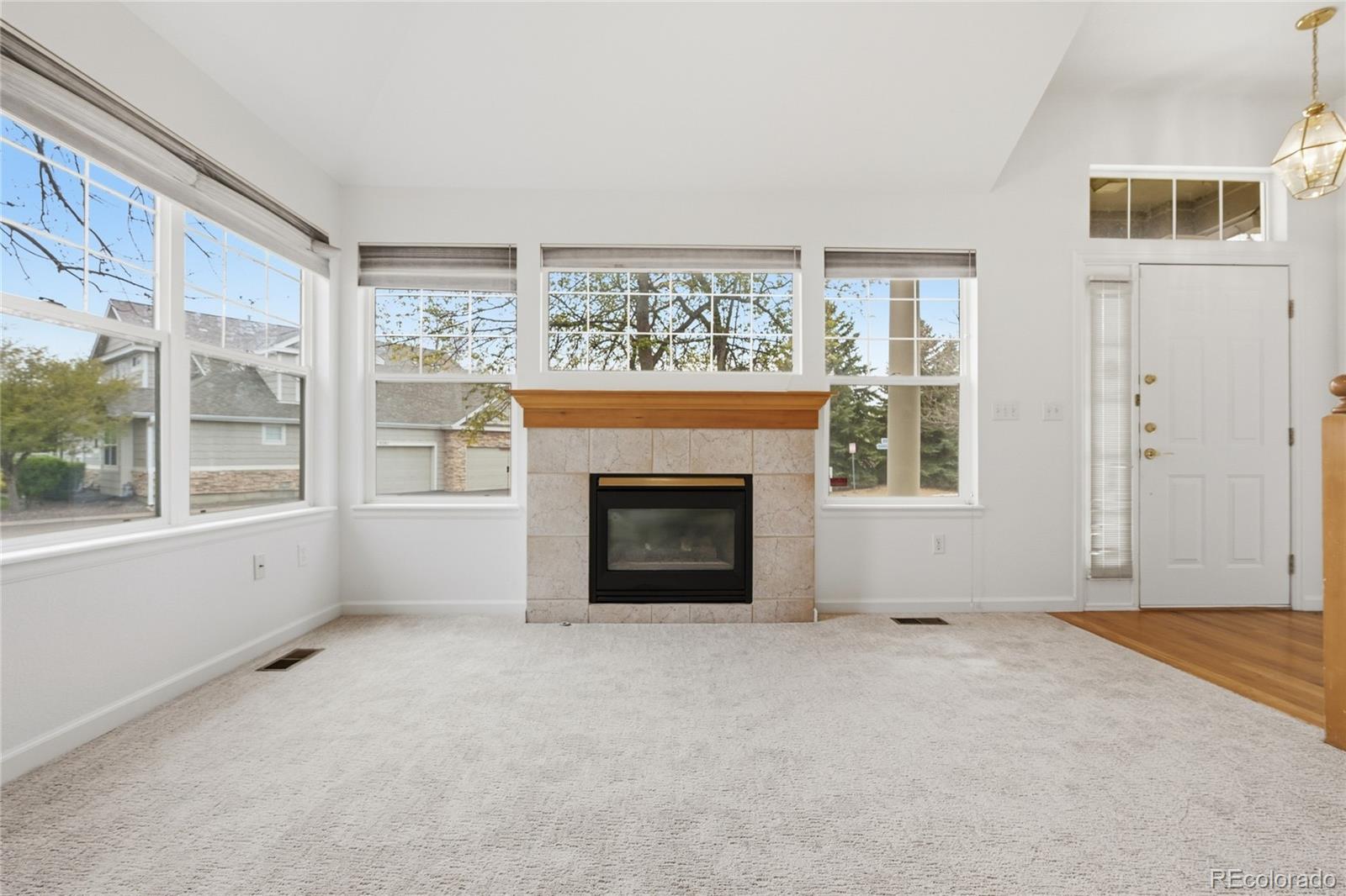 6383 Deframe Way Arvada, CO 80004 - Photo 10 of 49 an empty room with a fireplace and windows