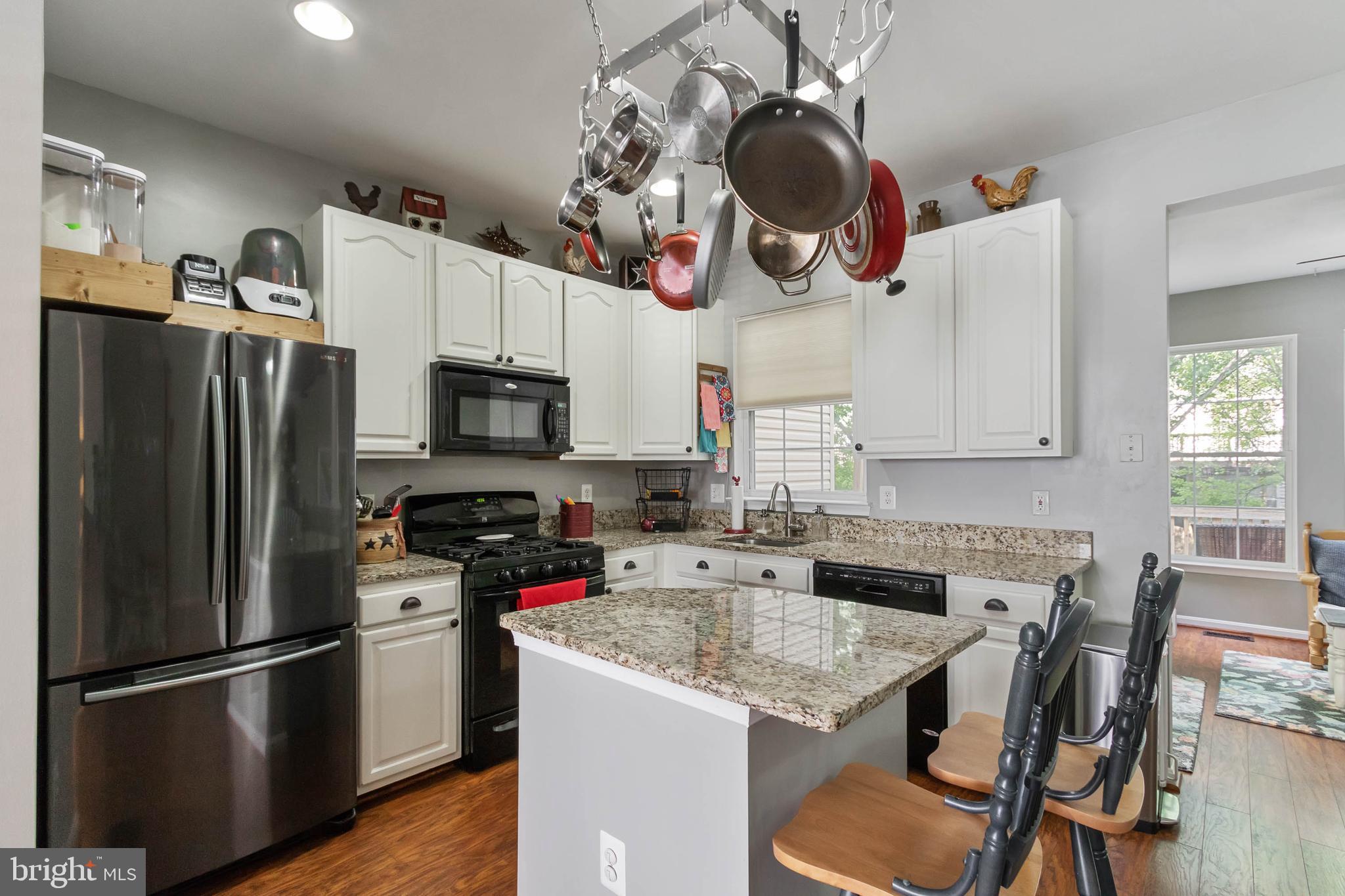 20385 Farmgate Terrace Ashburn, VA 20147 - Photo 7 of 27 a kitchen with stainless steel appliances granite countertop a sink dishwasher a refrigerator microwave and stove with wooden floor