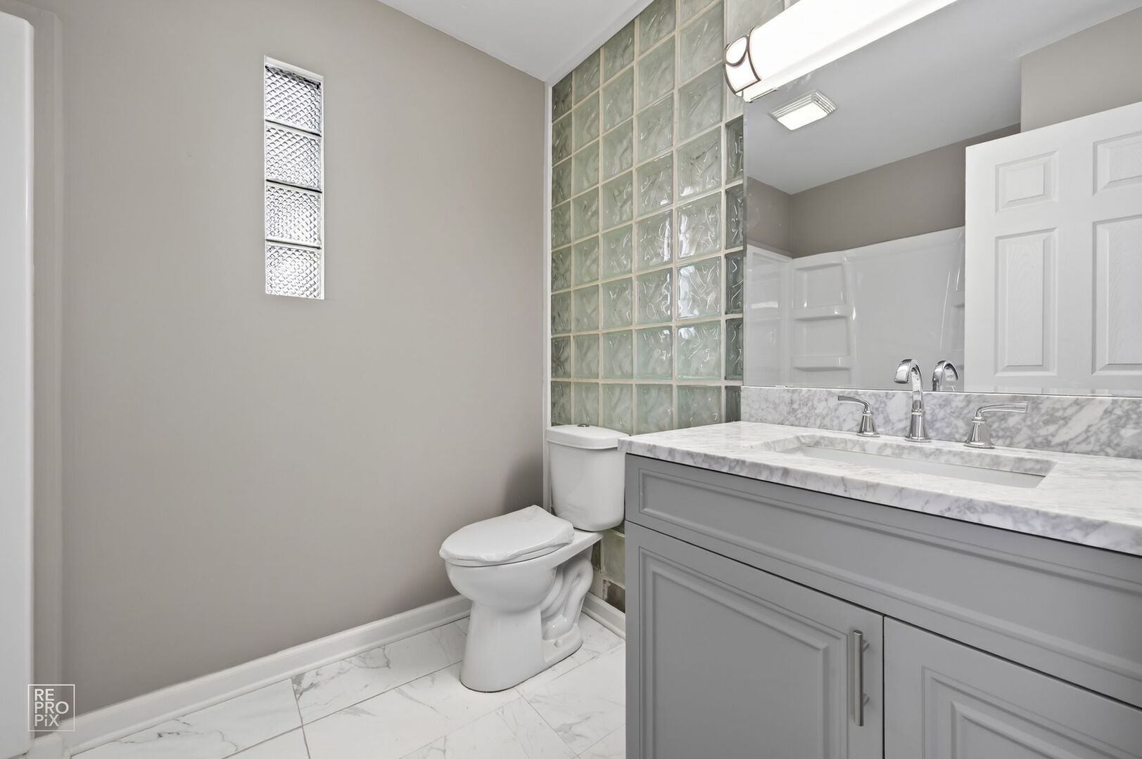 4680 West 83rd Street Chicago, IL 60652 - Photo 13 of 22 a bathroom with a granite countertop toilet a sink and mirror